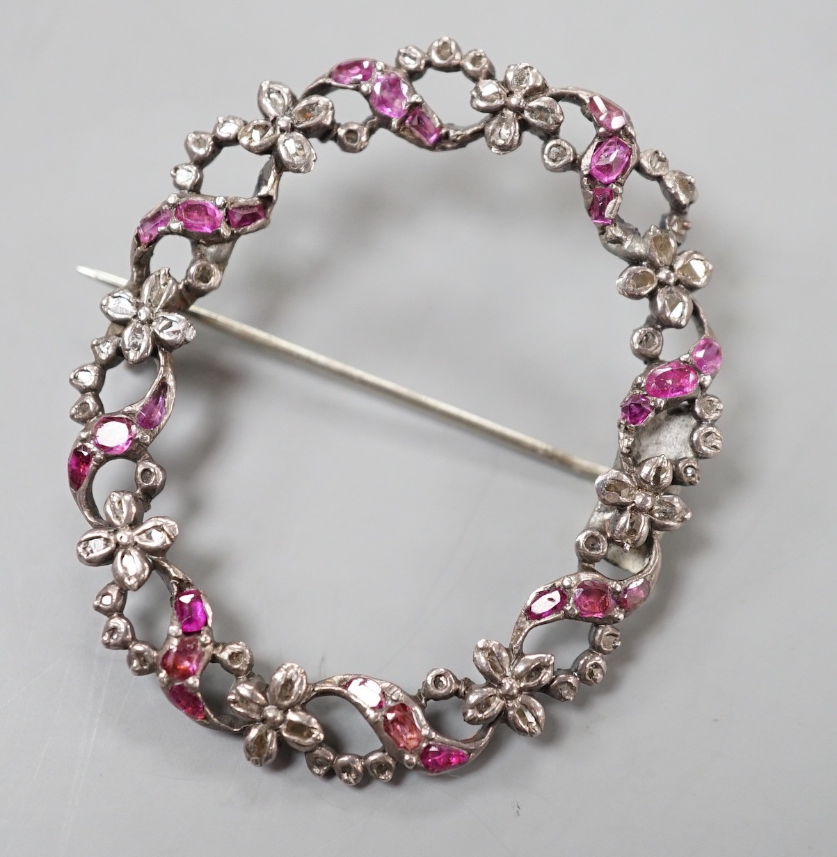 A 19th century white metal rose cut diamond and ruby set open work oval wreath brooch, 44mm.